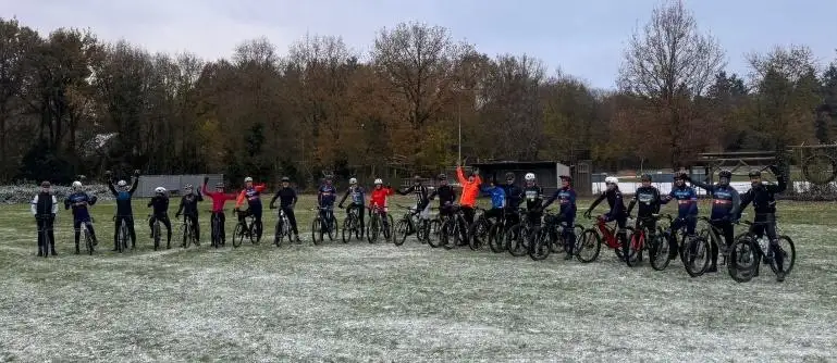 Deelnemers aan de Soeprit op een rij met hun fietsen op het besneeuwde bikepark