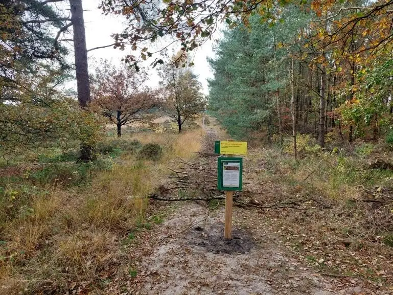 Een afgesloten bospad met een bordje van de gemeente
